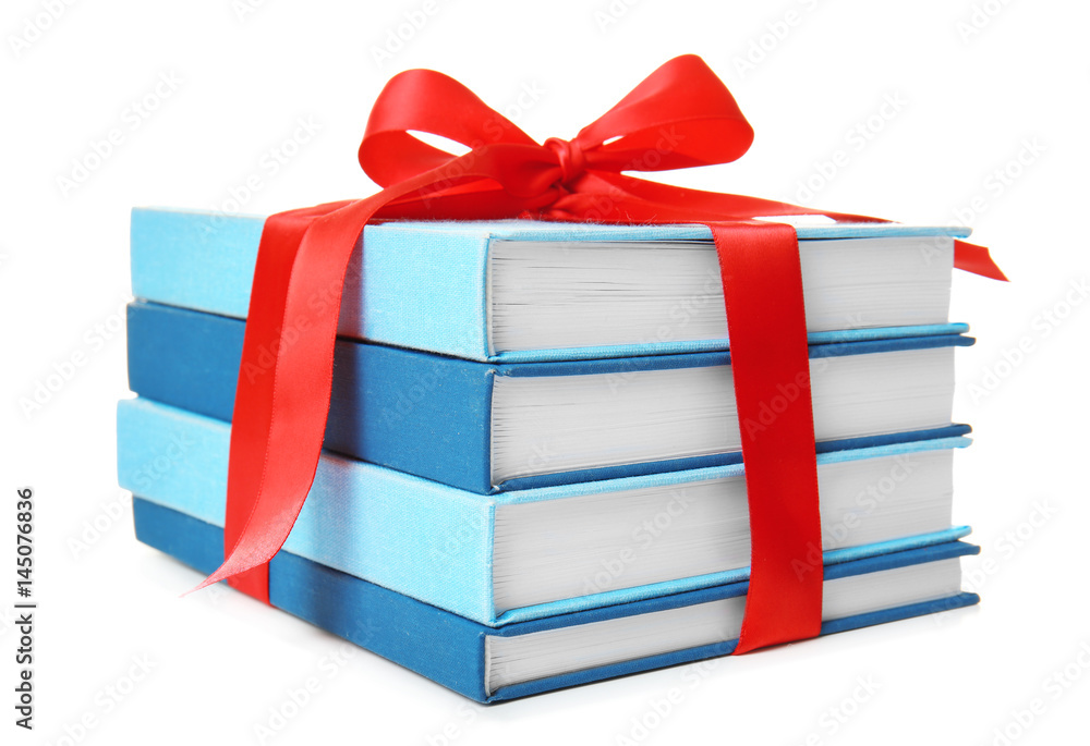 Naklejka premium Stack of books with ribbon as gift on white background