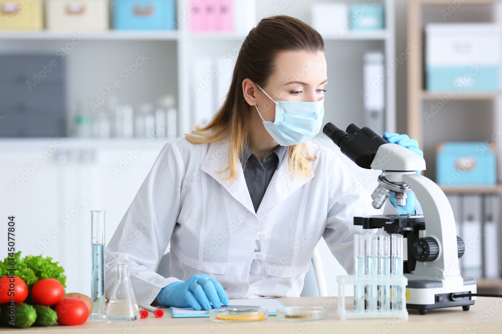 Young female nutritionist testing food samples in laboratory Young female nutritionist testing food samples in laboratory
