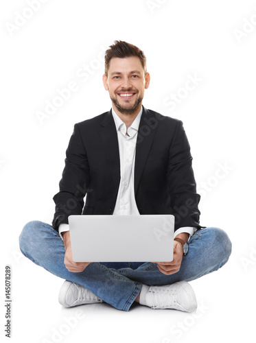 Handsome young man with lap...