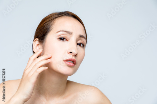 middle aged woman who checks her skin. acne treatment.