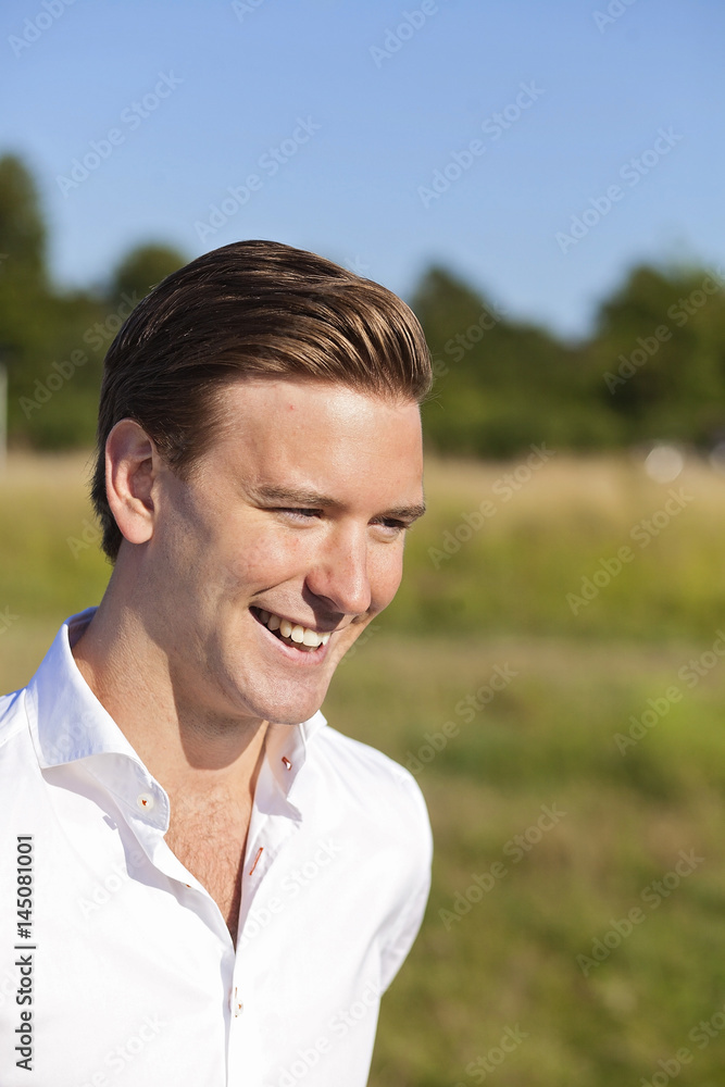 Smiling young man looking away at field