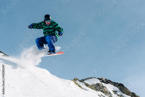 snowboarder is riding and jump from snow hill