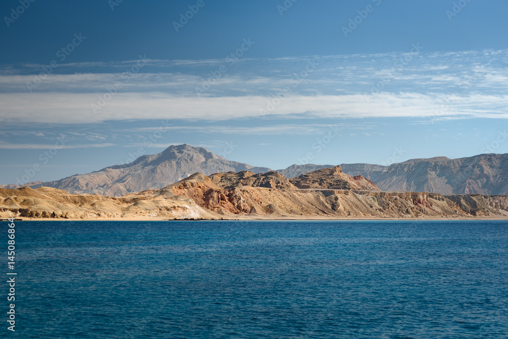 View at the desert island Tiran in Red sea. Landscape with an uninhabited island in sea with clear turquoise water. Vacation in an exotic country.