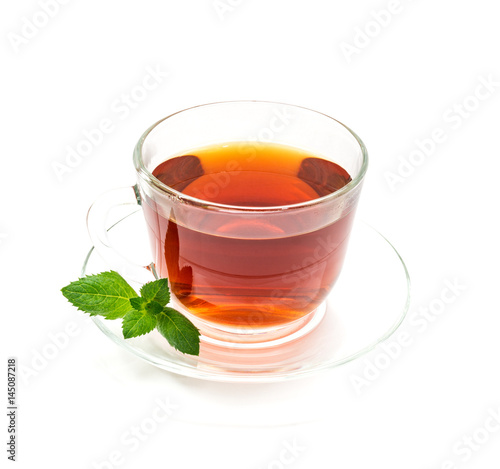 Isolated transparent cup of black tea with mint leaf on white