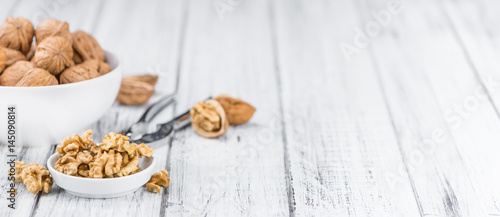Portion of Cracked Walnuts on wooden background (selective focus)