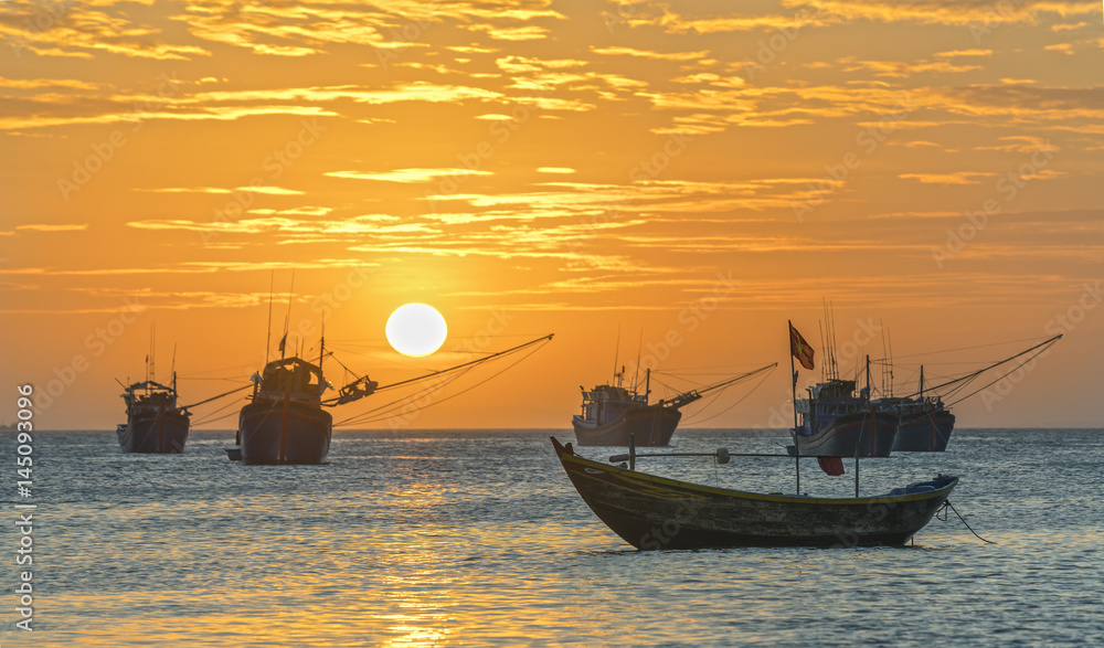 Fototapeta premium Mui Ne, Vietnam - February 19th, 2017: Vietnamese fishing village, Landscape sunset with sea and traditional colorful fishing boats in Mui Ne, Vietnam