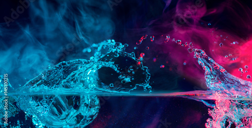colorful splashes with smoke over water surface