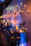 Indoors wedding decoration in the evening with candles and fir branches