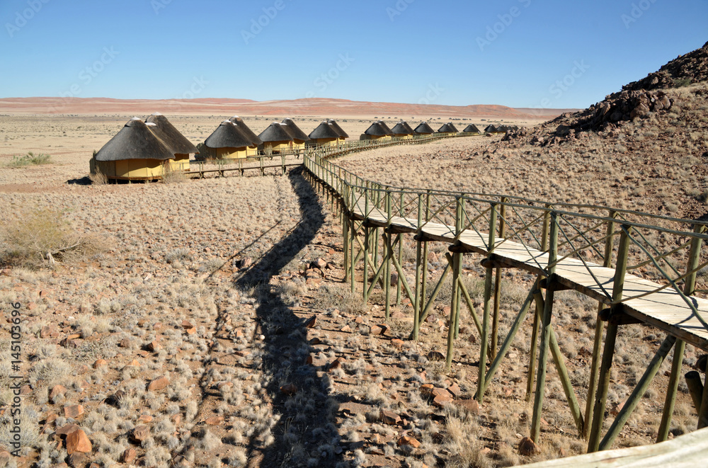 Unterkünfte für Touristen mit langem Steg  in der Wüste Namibias