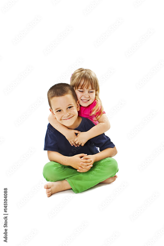 Loving sister and little brother hugging. Isolated on a white background. Loving sister and little brother hugging. Isolated on a white background.