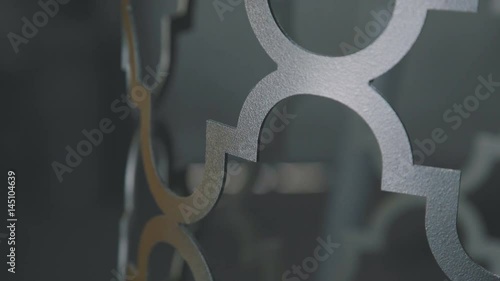 Close-up: painting a metal decorative element in gold and gray using a spray gun. An electric paint sprayer covers a gold piece of metal. Artistic forging of metal photo