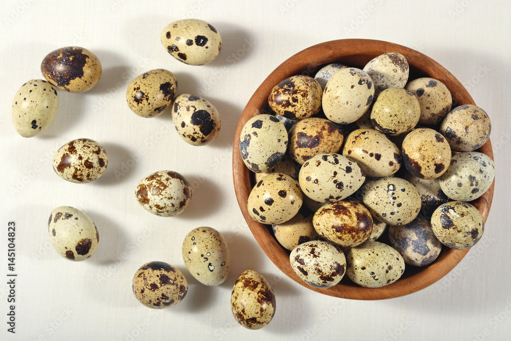 Quail eggs in a wooden bowl in a sacking Quail eggs in a wooden bowl in a sacking