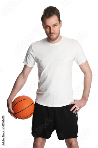Focused staring basketball player wearing black shorts and a white shirt, holding a basketball. Standing in front of a white background. © _robbie_