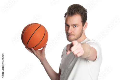 Focused staring basketball player wearing black shorts and a white shirt, holding a basketball. Standing in front of a white background.