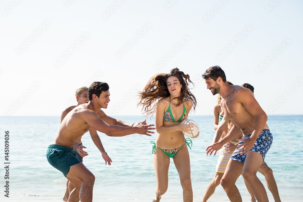 Friends playing on shore at beach