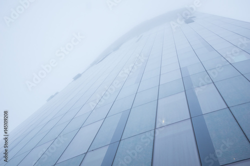 Tall skyscraper disappears in the fog