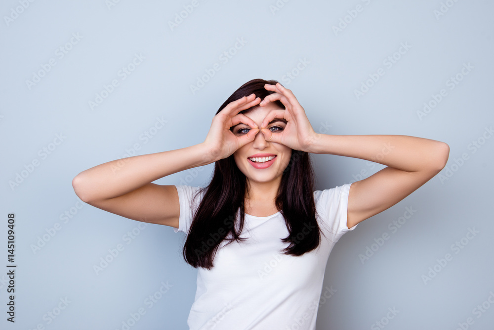 Attractive young laughing woman having fun and making binoculars using her hands Attractive young laughing woman having fun and making binoculars using her hands