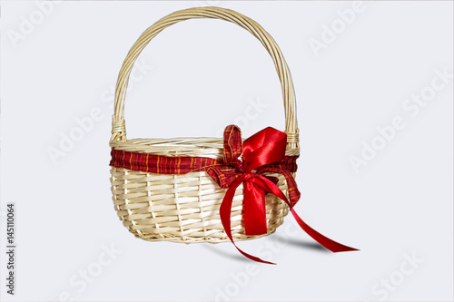 Beautiful wicker basket with red bow isolated on white background