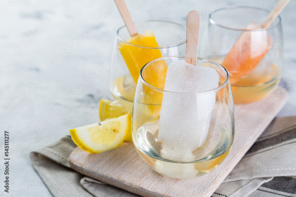 Colorful ice popsicles with wine in glasses Colorful ice popsicles with wine in glasses