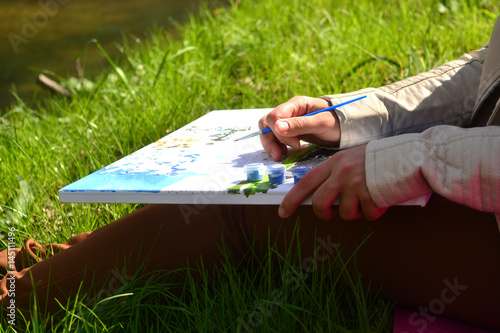 Number painting in womans hands.