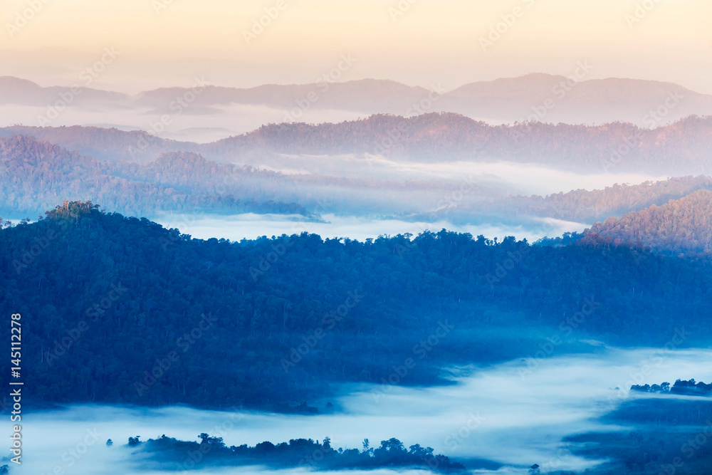 High angle view over tropical mountains with white fog in early morning in Thailand.