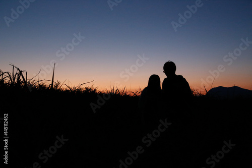 young couple silhouette mountain