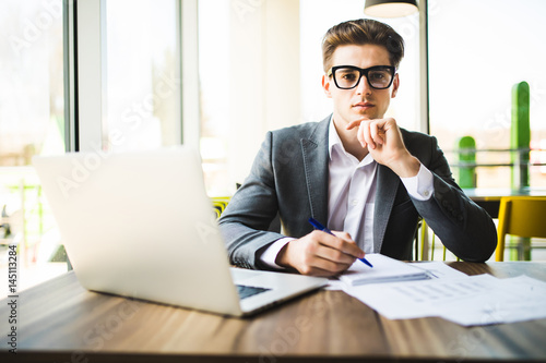 Fotografie Happy man entering data from home on laptop an office work place