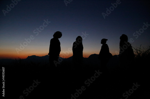 Watch the evening with a group on a hill