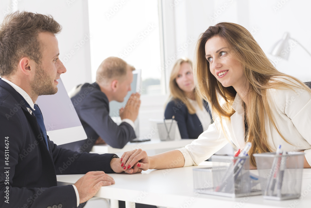 Businesswoman teasingly touching colleague during work Businesswoman teasingly touching colleague during work
