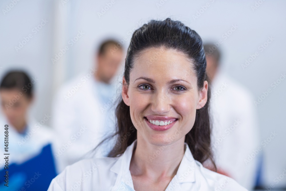 Smiling dentist standing at dental clinic Smiling dentist standing at dental clinic