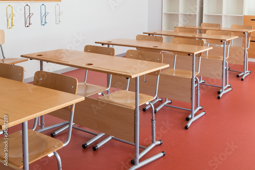 Empty classroom with wooden desks and chairs