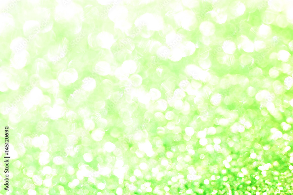 Green bokeh texture. Festive glitter background with defocused lights