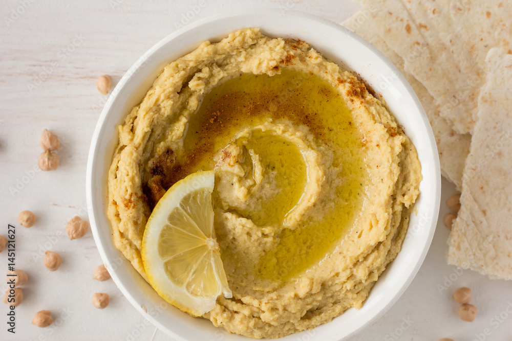 Hummus with spices and lemon in white bowl Hummus with spices and lemon in white bowl