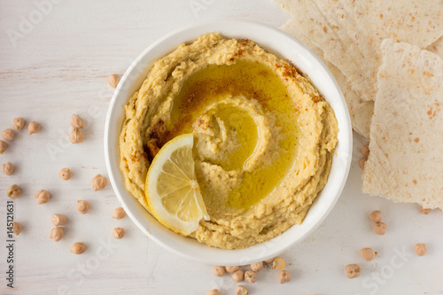 Hummus with spices and lemon in white bowl