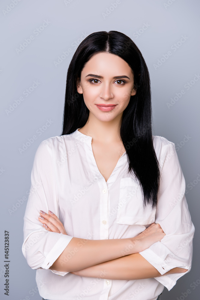 Portrait of beautiful cute young woman keeping crossed hands and looking at camera Portrait of beautiful cute young woman keeping crossed hands and looking at camera