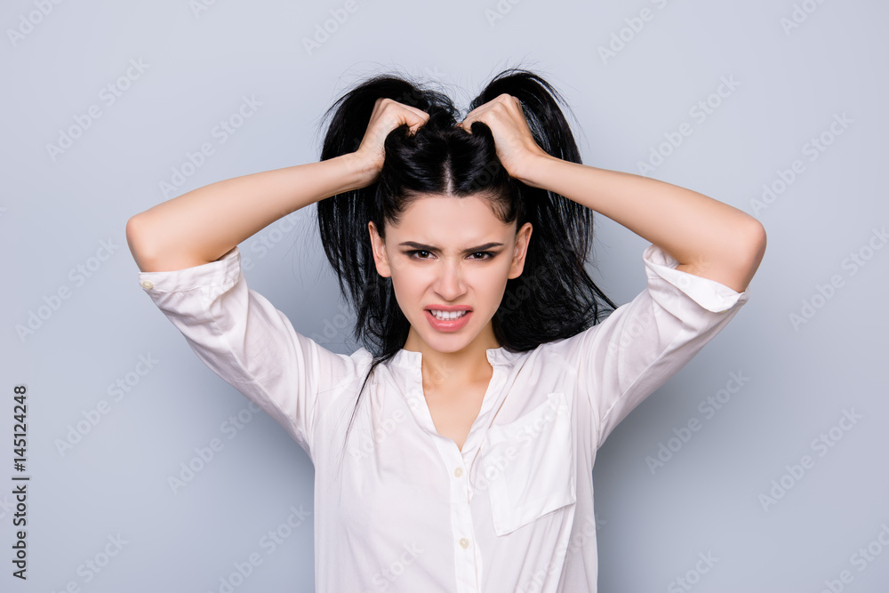 Bad mood. Overworked furious stressed young woman in rage holding head with black hair Bad mood. Overworked furious stressed young woman in rage holding head with black hair