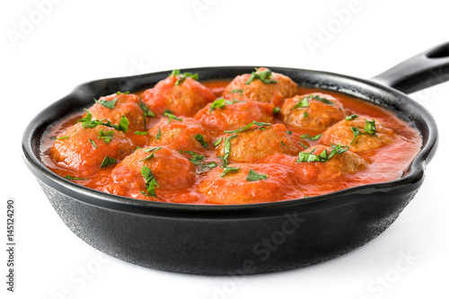 Meatballs with tomato sauce in iron frying pan isolated on white background