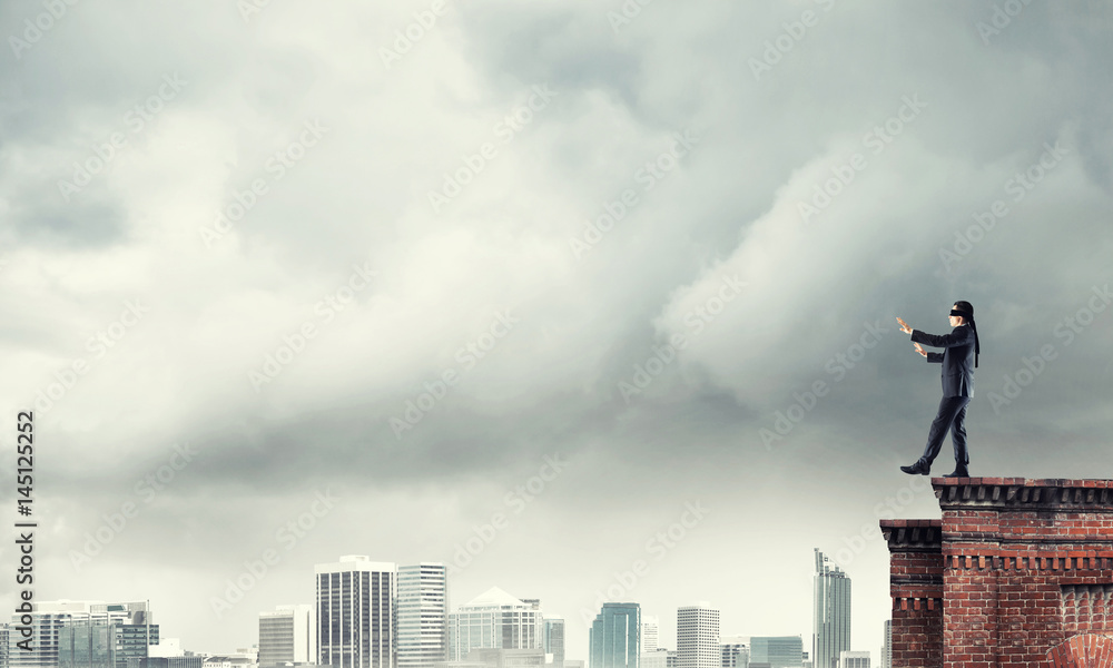 Danger and risk concept with businessman making step from edge Danger and risk concept with businessman making step from edge