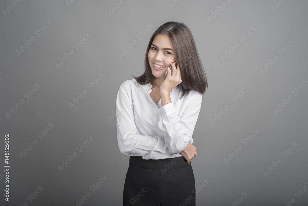 Beautiful business Woman using smartphone on grey background Beautiful business Woman using smartphone on grey background