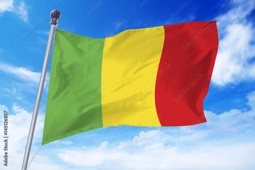 Flag of Mali developing against a clear blue sky Flag of Mali developing against a clear blue sky