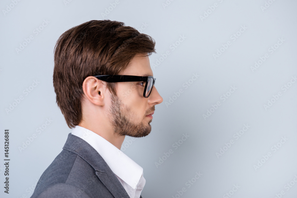Side-view close-up portrait of young successful serious man in glasses  standing on gray background Stock Photo | Adobe Stock