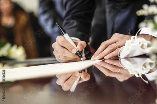 mano che firma con una penna un documento photo