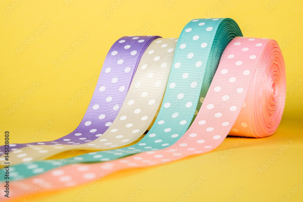 Fototapeta premium Closeup of ribbon roll over colorful background