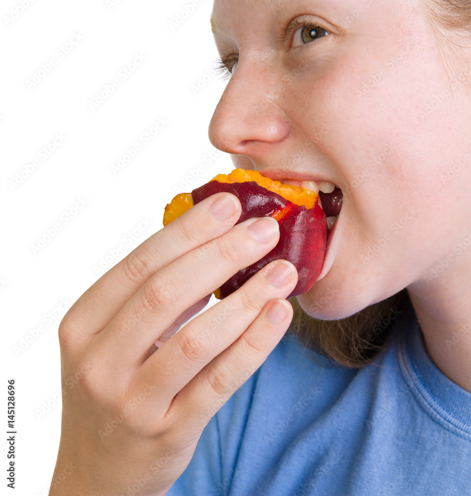 Wholesome teenage girl eating a fresh organic peach Wholesome teenage girl eating a fresh organic peach