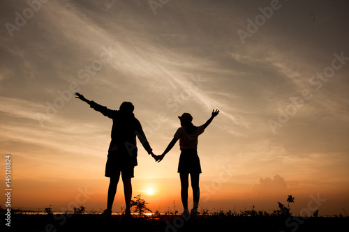 Romantic couple at colorful sunset on background