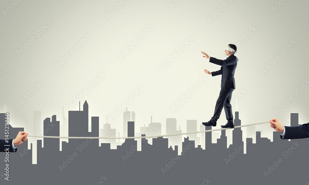 Business concept of risk support and assistance with man balancing on rope Business concept of risk support and assistance with man balancing on rope