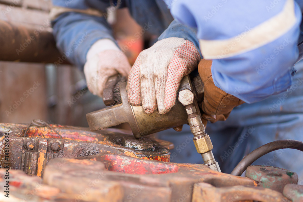 worker's hand fixing a piece of equipment worker's hand fixing a piece of equipment
