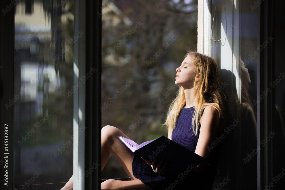 Fototapeta premium Pretty girl sleeping with book at open window