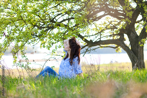 девушка в поле, сидящая под деревом