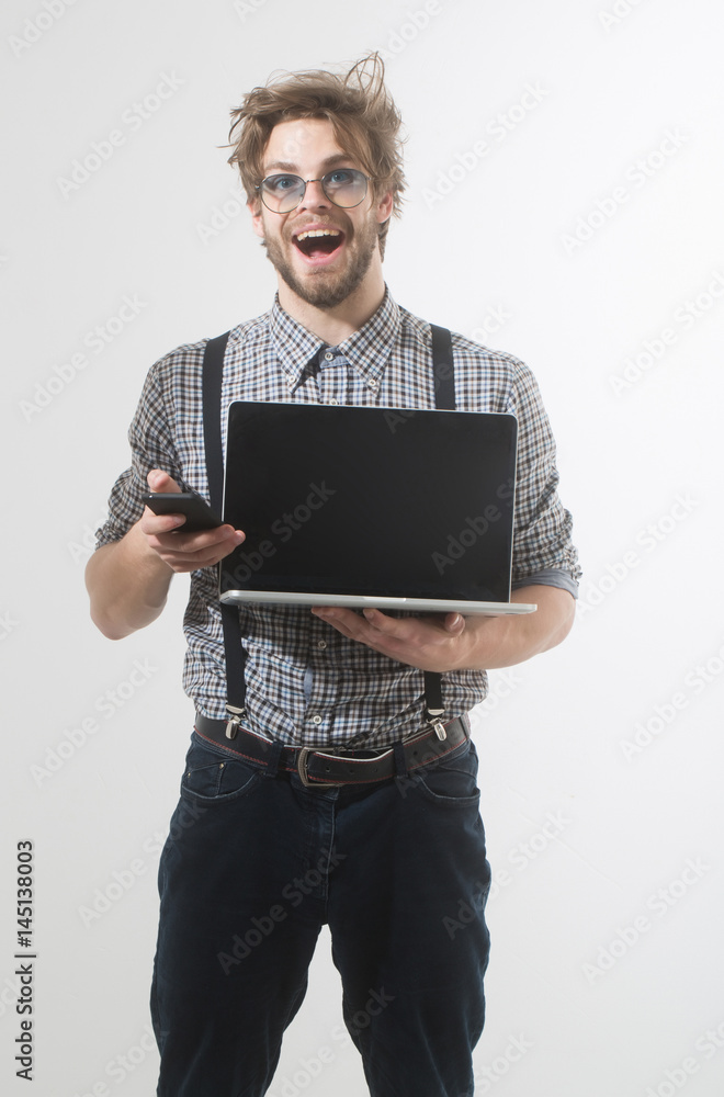 Happy handsome man talking on smartphone with laptop Happy handsome man talking on smartphone with laptop